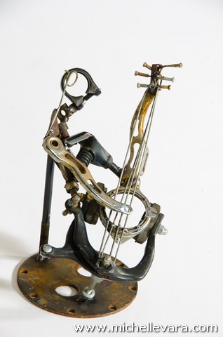Musician made of recycled bicycle parts welded. Bass player, guitarist, metal sculpture