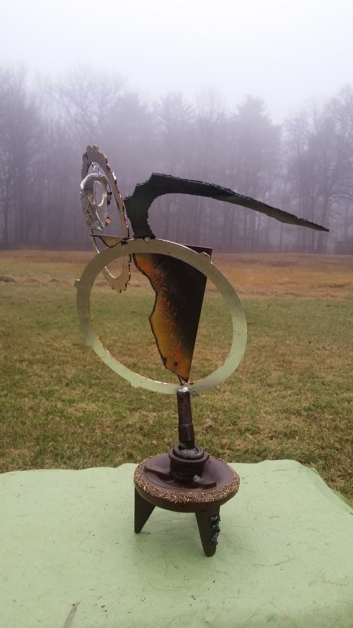 Welded metal sculpture with brass chips and glass, finished in silver leaf and paint. Amulet is a piece of jewelry to be worn.