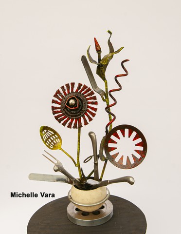 Flower arrangment made with common household objects welded into metal sculpture.